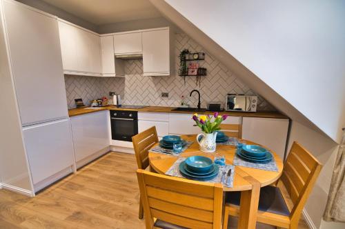 cocina con mesa y sillas en Modern & Cosy apartment in the heart of the historic old town of Aberdeen, free WiFi, free parking, en Aberdeen