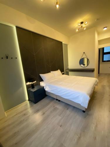 a bedroom with a large bed with a large headboard at 北緯23點5度民宿-車位可預訂 in Hualien City