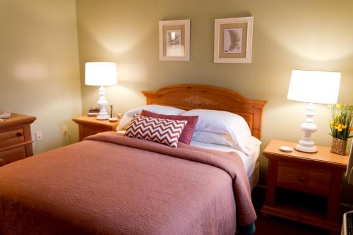 a bedroom with a large bed with two lamps on tables at Summers Inn Ludington - Adults Only in Ludington