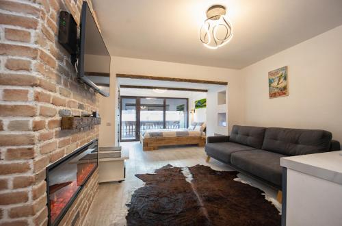 a living room with a couch and a brick wall at Studio Rubio in Poiana Brasov