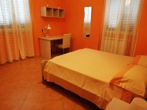 1 dormitorio con cama, mesa y escritorio en Casa Serena, en Messina