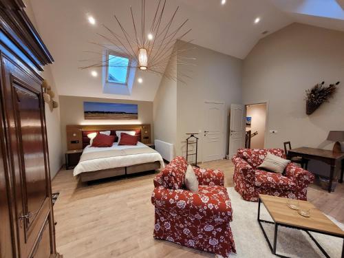 a living room with a bed and two chairs at Les Chanterolles in Chaumont-Gistoux