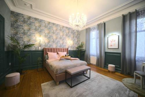 une chambre avec un lit et un lustre dans l'établissement Royal Room jacuzzi haut de gamme centre ville, à Mulhouse