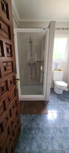 een badkamer met een douche, een toilet en een deur bij maison nathalia in Jávea
