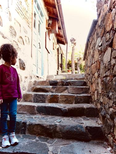 a little girl standing on the steps of a building at Sophias Cottage in Askas