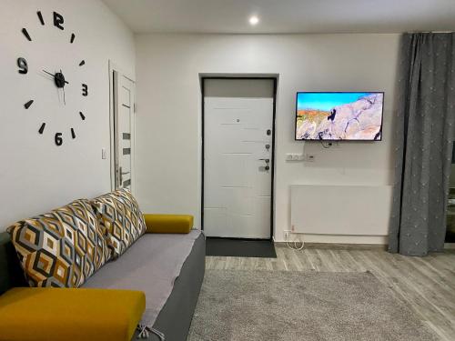 ein Wohnzimmer mit einem Sofa und einem Fernseher an der Wand in der Unterkunft Вілла Бовч in Jaremtsche