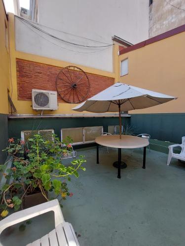 a patio with a table and an umbrella at BA Stop Hotel House in Buenos Aires