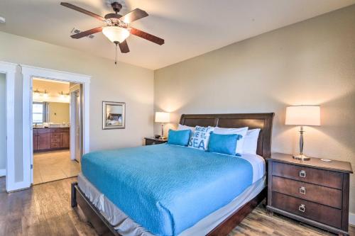 a bedroom with a blue bed and a ceiling fan at Driftwood Galveston Resort Escape with Deck and View in Galveston