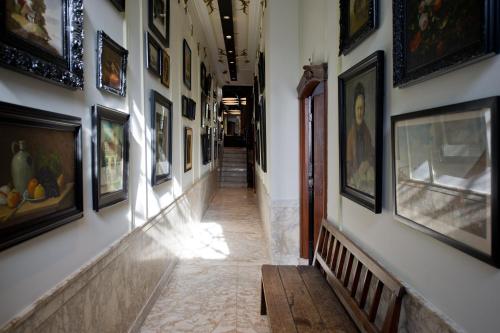 a hallway with paintings and pictures on the walls at Canal House in Amsterdam