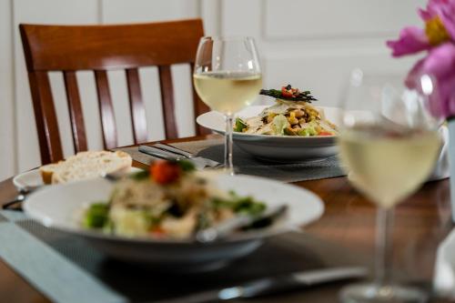 a table with two plates of food and glasses of wine at Hotel & Restaurant Tanne in Fischingen