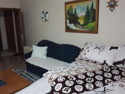 a living room with a bed and a couch with pillows at Apartament KiÇi Korce in Korçë