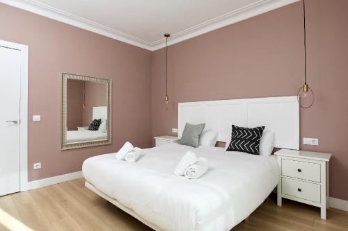 1 dormitorio con 1 cama blanca grande y espejo en Casa Cosi - Casanova 6 en Barcelona