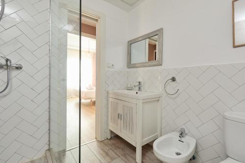 a white bathroom with a toilet and a sink at Casa Cosi - Casanova 6 in Barcelona