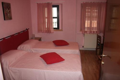 two beds in a room with pink walls at Locanda del Pittore in Arcumeggia