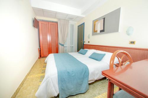 a bedroom with a bed and a table and a desk at Hotel Della Baia in Portovenere