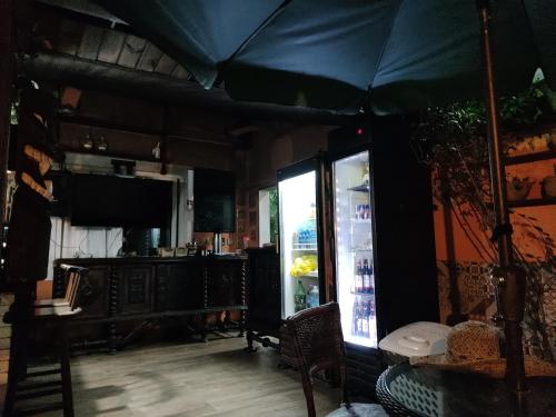 a large black umbrella in a room with a refrigerator at Airport Pousada in Cabo Frio