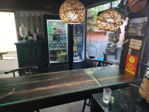 a table and chairs in a restaurant with a refrigerator at Airport Pousada in Cabo Frio