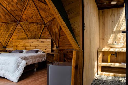 ein Schlafzimmer mit einem Bett in einer Holzhütte in der Unterkunft GLAMPING LA CIMA NEUSA in Casablanca