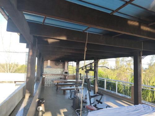 an outdoor deck with a table and chairs and a bench at Airport Pousada in Cabo Frio