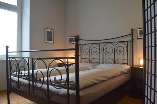 Nap Club - stylish flat in lively neighborhood في برلين: غرفة نوم مع سرير مع إطار من الحديد المطاوع