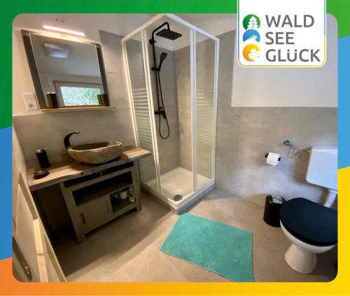 a bathroom with a shower and a toilet and a sink at Glückshütte in Unterwellenborn