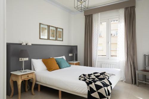 ein Schlafzimmer mit einem großen weißen Bett und einem Fenster in der Unterkunft Casa Cosi - Casanova 4 in Barcelona