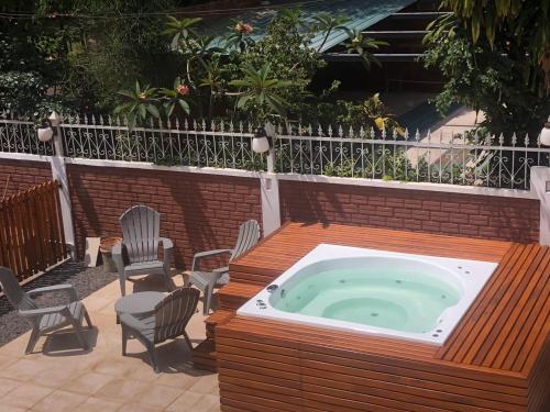 a hot tub in a deck with chairs in a patio at Hotel AATRAC Iguazú in Puerto Iguazú
