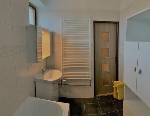 uma casa de banho branca com um lavatório e um WC em Příjemný řadový rodinný dům se zahradou em Cheb