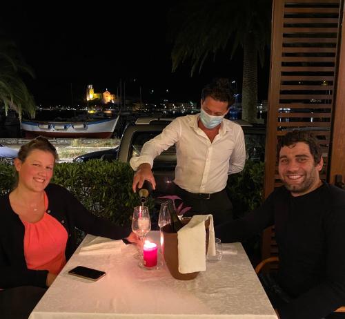 a man in a mask is pouring wine at a table at Hotel Della Baia in Portovenere