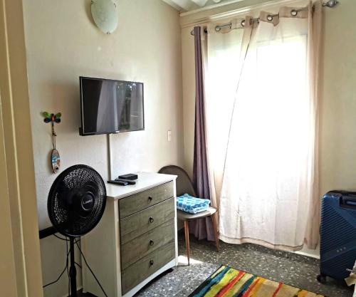 Habitación con ventilador y tocador con TV. en Casa India Dormida, en El Valle de Antón