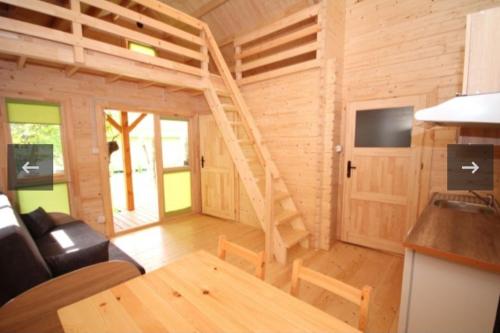 a living room with a staircase in a tiny house at Domki w sadzie Stegna in Stegna