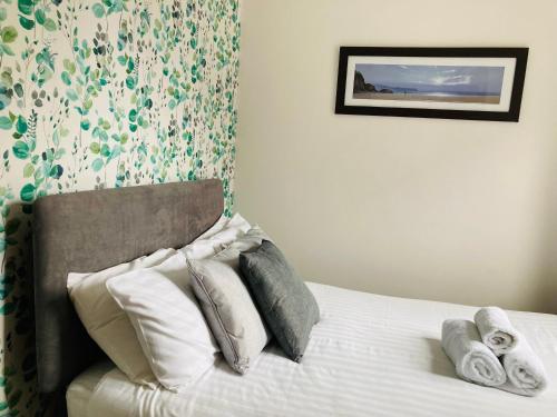 a bedroom with a bed with pillows on it at The Wentworth Guest House in Paignton
