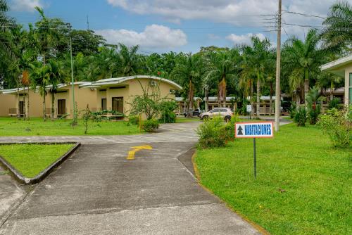 a sign in front of a house with a driveway at Hotel Los Rios in Guácimo