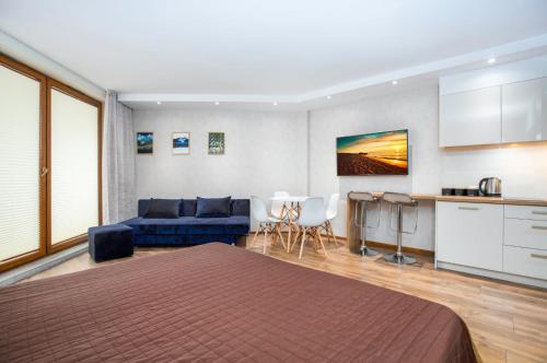 a room with a bed and a kitchen and a couch at Maloves Apartament przy plaży II in Władysławowo