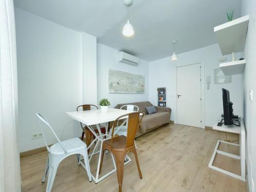 una sala de estar con una mesa, sillas y un sofá en Apartamento Soho centro malaga, en Málaga