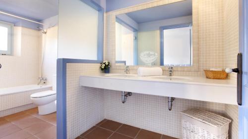 a bathroom with two sinks and a toilet and a mirror at 1 Past2 - Llafranc in Llafranc