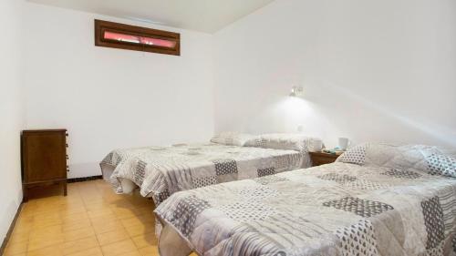 drie bedden in een kamer met witte muren bij 1Pele PL - Llafranc in Llafranc