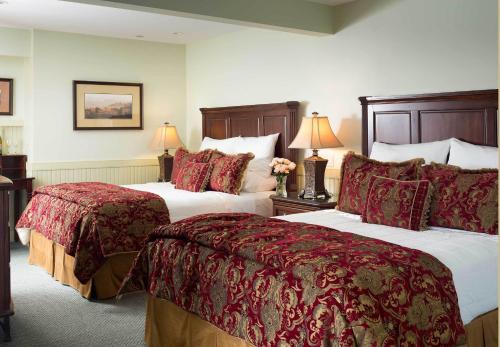 a hotel room with two beds and two lamps at Grand Harbor Inn in Camden