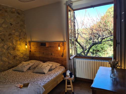 Vinsobresにあるgîte du Domaine Jaumeのベッドルーム1室(ベッド1台、大きな窓付)