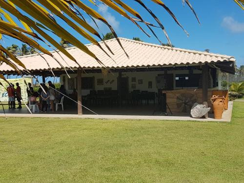 a house with a roof with people standing outside at Tree Bies Resort Subaúma - Apartamento particular in Subaúma