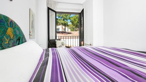 Un dormitorio con una cama con una manta de colores. en Apartment Sabin - Llafranc, en Llafranc