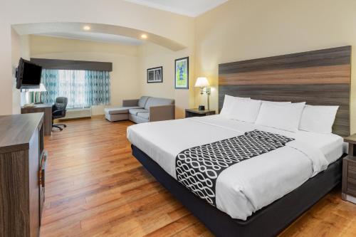 a hotel room with a large bed and a couch at La Quinta by Wyndham Garland Harbor Point in Garland