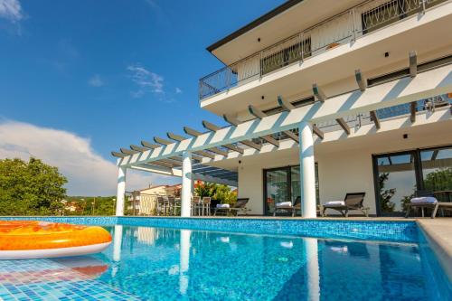 una piscina frente a una casa con un edificio en Luxury Villa Rivabel, en Malinska