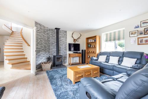 a living room with a blue couch and a fireplace at Copse Gate Farm in Bridport
