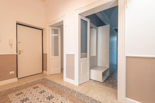 Un pasillo vacío con una puerta y un espejo. en Nitti43 luxury apartment, en Taranto