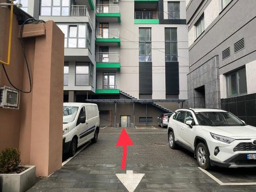 two cars parked in a parking lot next to a building at Stylish 1 bedroom studio near Most City in Dnipro