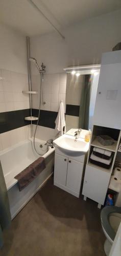 a bathroom with a sink and a bath tub at Résidence Front de mer Cabourg - Accès direct plage in Cabourg