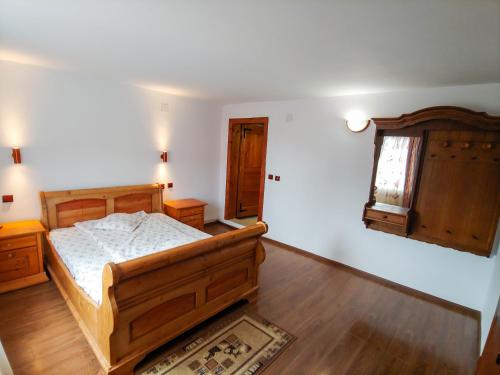a bedroom with a wooden bed and a window at Cabana Liliana in Arieşeni