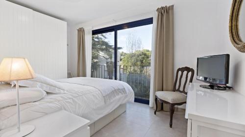 een slaapkamer met een bed, een tv en een raam bij Apartment Sta Rosa1 - Llafranc in Llafranc