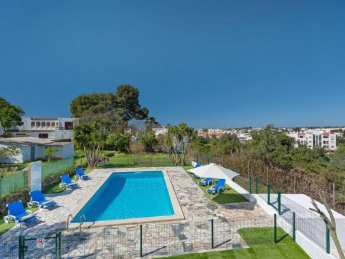 an overhead view of a swimming pool with chairs and umbrellas at Carvoeiro Peaceful Villa with Pool in Carvoeiro